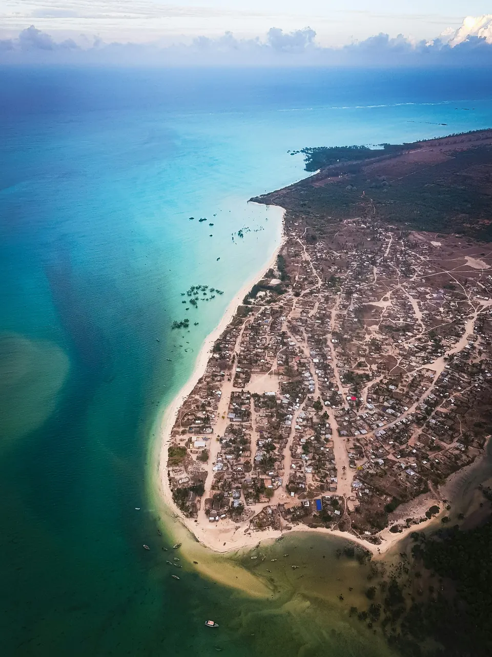 Aerial view of a sandy spit, a village and turquoise Indian Ocean water at Arimba, Mozambique.